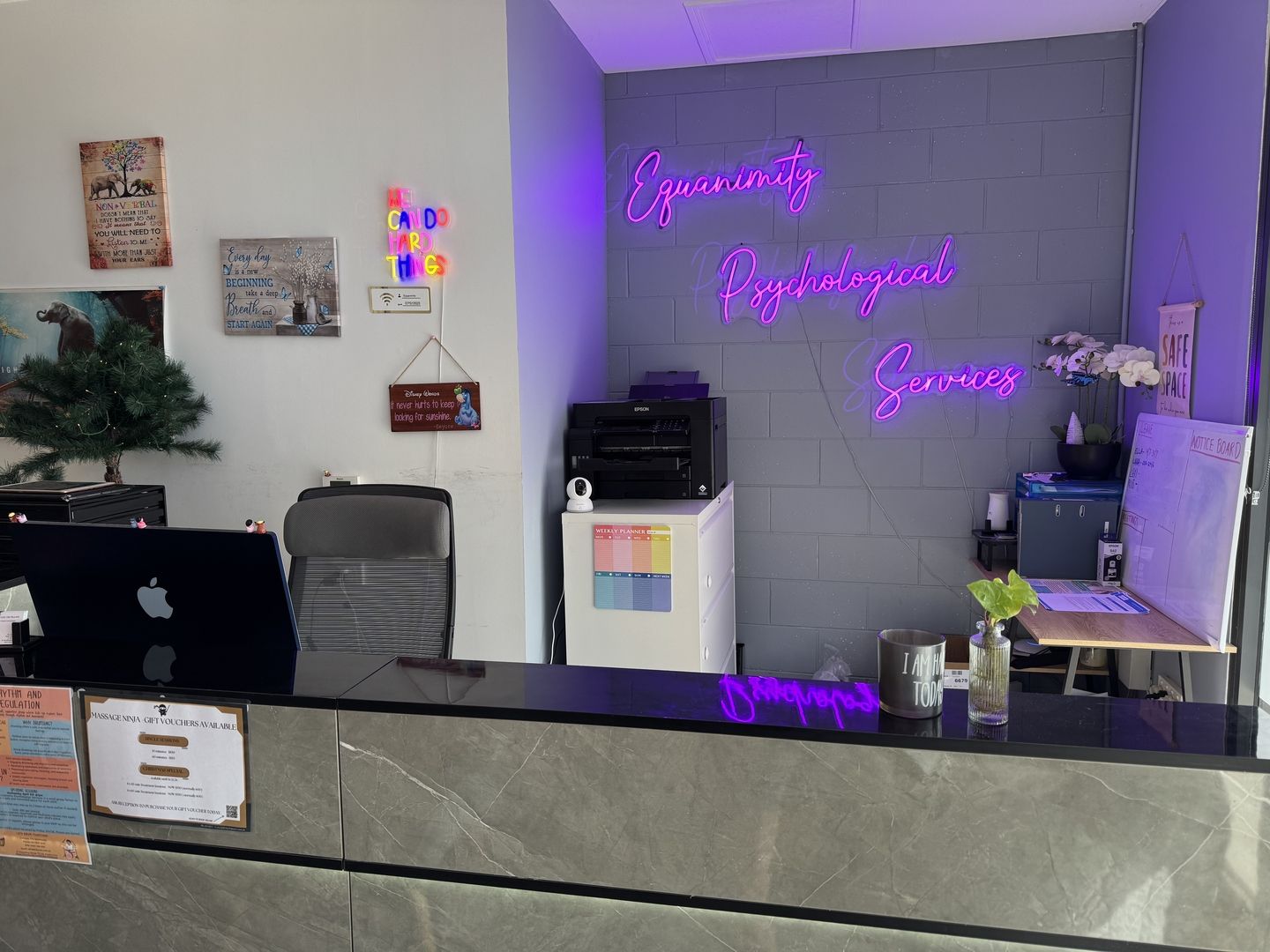 The Equanimity reception desk, branded with the practice's neon sign